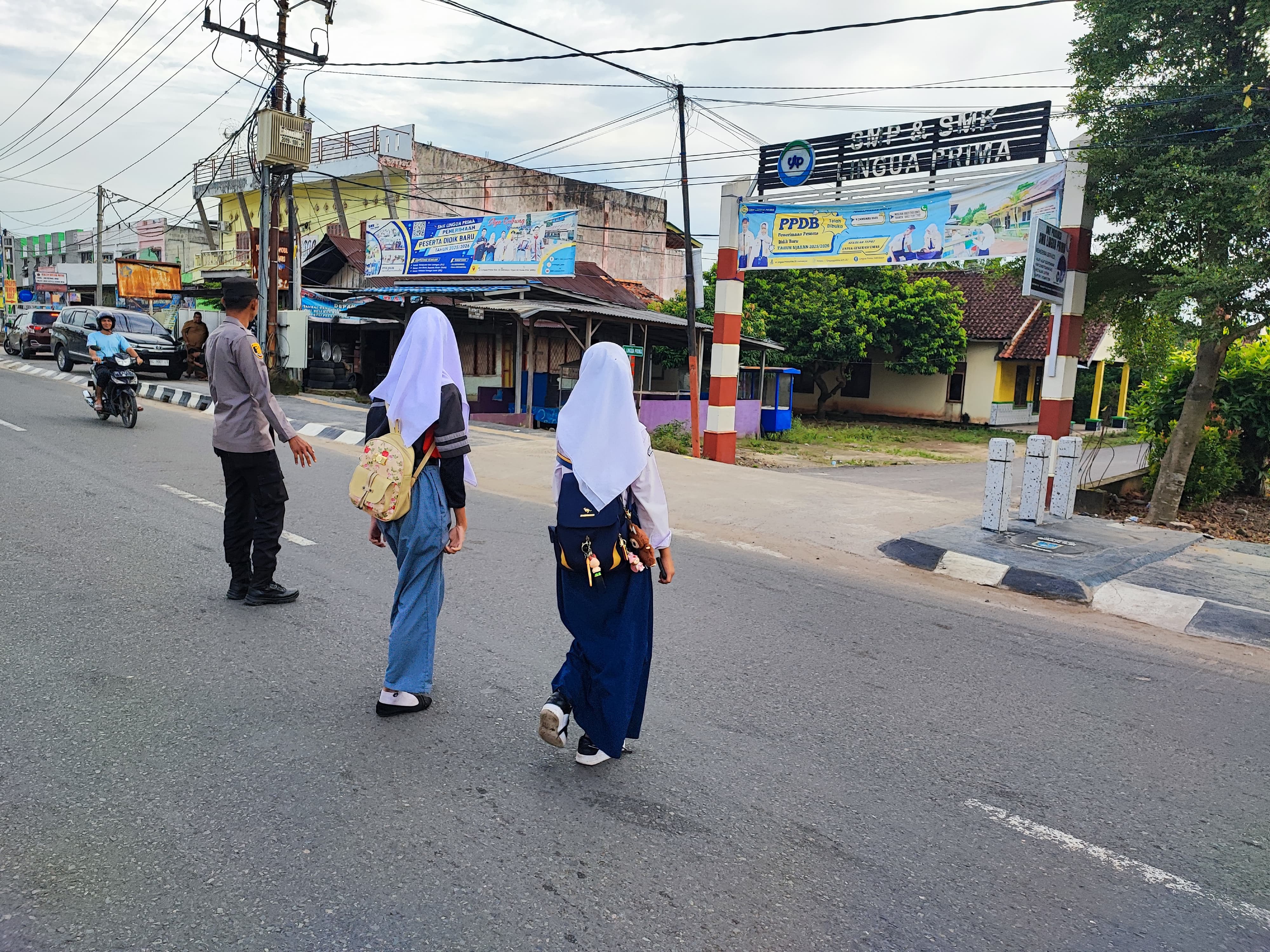 Polsek Indralaya Lakukan Pengaturan Lalu Lintas di Simpang SMA Lingua Prima Ogan Ilir, Bantu Siswa Menyeberang