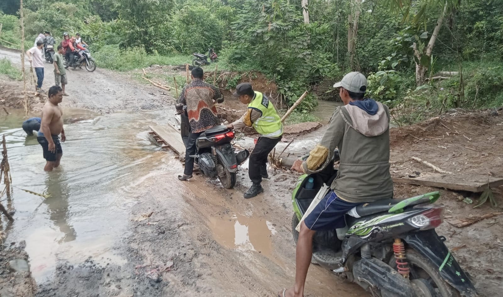 Jalan Provinsi di Ogan Ilir Nyaris Putus, Anggota Polsek Tanjung Batu Bantu Pengendara Seberangi Sungai