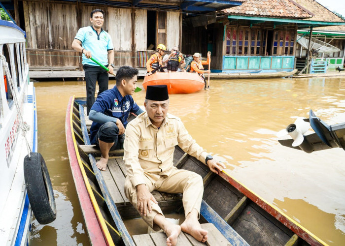 Naik Perahu, Pj H Apriyadi Tinjau dan Beri Bantuan Korban Banjir di Ulak Embacang