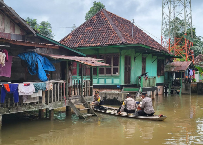 Gunakan Perahu, Kapolsek Tanjung Batu Ogan Ilir Susuri Rumah Warga Terendam Banjir dan Berikan Bantuan