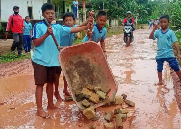 Tanamkan Sikap Peduli, Pelajar SDN 01 Nusa Maju, Gotong Royong Timbun Jalan Rusak