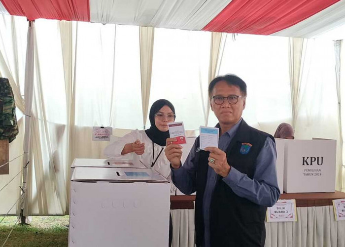 Pj Bupati OKI dan Istri Nyoblos di TPS 04 Sukadana Kayuagung