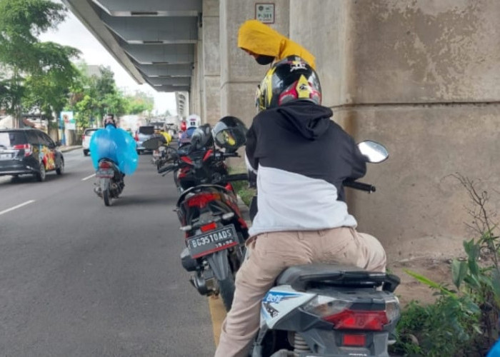 Hujan Deras, Waspada Banyak Pengguna Sepeda Motor Berteduh di Bawah LRT Palembang